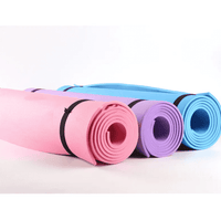 Set of pastel pink, purple, and blue yoga mats rolled up with black straps, designed for versatile workout routines and joint cushioning.