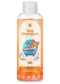 Transparent bottle of natural dog shampoo with orange liquid and bath bomb balls at the bottom, featuring a cute cartoon cat in a bathtub on the label