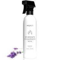 Close-up of white pet detangling spray bottle with black spray nozzle, lavender flowers at base, 16oz, for dogs and cats