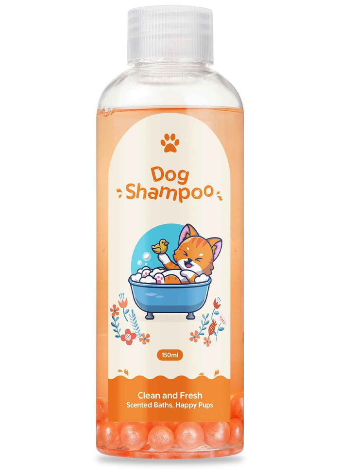 Clear plastic bottle of natural dog shampoo with orange liquid and bath bomb balls at the bottom, featuring a cute cartoon cat bathing illustration on the label